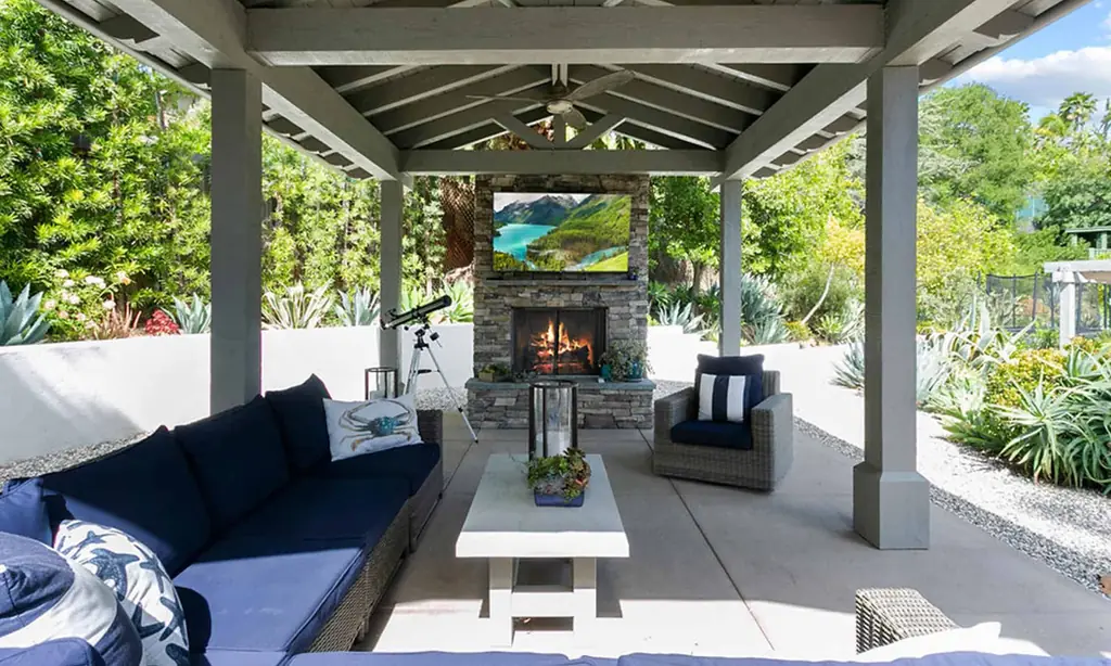 A covered patio with a stone fireplace and succulent planting in Southern California light